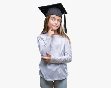 Genç güzel kız çene düşünme hakkında soru, dalgın ifade üzerine el ile izole arka plan üzerinde yüksek lisans şapkası. Düşünceli yüzüyle gülümsüyor. Şüphe kavramı.