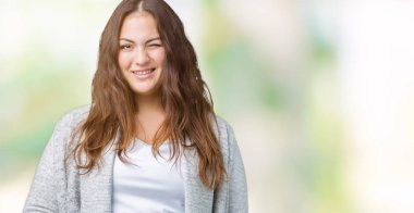 Artı boyutu genç kadın güzel kış ceket üzerinde arka plan seksi bir ifadeyle, neşeli ve mutlu yüzünü kameraya bakarak göz kırpıyor izole.