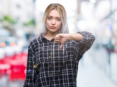 Genç Sarışın kadın yüzünden mutsuz ve kızgın ret gösterilen ve başparmak aşağı hareketi ile negatif seyir izole arka plan. Kötü ifade.