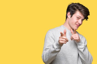 Fotoğraf makinesi ile mutlu ve komik yüz için parmakları işaret izole arka plan üzerinde sweatshirt giyen genç yakışıklı sportif adam. İyi enerji ve vibes.