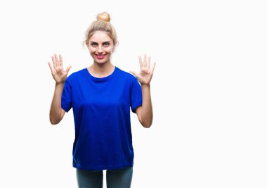 Gösterilen ve parmakları ile işaret izole arka plan üzerinde mavi t-shirt giyen genç güzel sarışın ve mavi gözlü kadın kendinden emin ve mutlu gülümseyerek süre on numara.