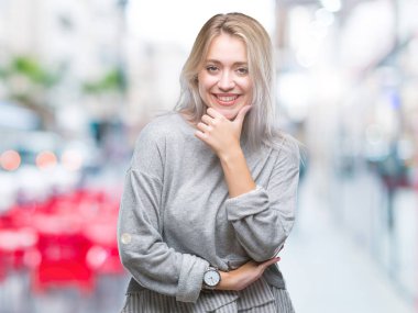 Genç Sarışın kadın yüzünden izole arka plan emin çapraz kollar ve çeneme kaldırdı el ile gülümseme ile kameraya bakıyor. Pozitif düşünce.