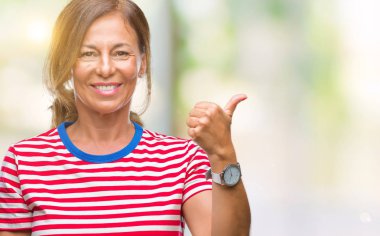 Orta yaş arıyor ve başparmak yanında yukarıyı mutlu yüz ile gülümseyen izole arka plan üzerine İspanyol kadın kıdemli.