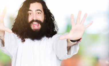 Gösterilen ve parmakları ile işaret İsa Mesih giyinen adam number ten kendinden emin ve mutlu gülümseyerek süre.