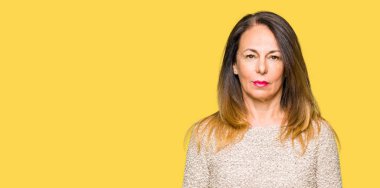 Yüzünde ciddi bir ifade ile moda kazak gevşek giyen güzel orta yaş kadın. Basit ve doğal kameraya bakıyor.