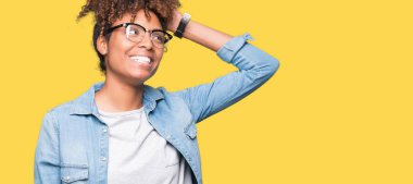 Güzel genç Afro-Amerikan kadın hareketi el ile kendine güvenen dokunaklı saç gülümseyerek, çekici poz izole arka plan üzerinde gözlük