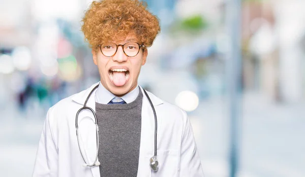 Молодой Красивый Доктор Медицинском Пальто Торчащий Язык Довольный Смешным Выражением — стоковое фото