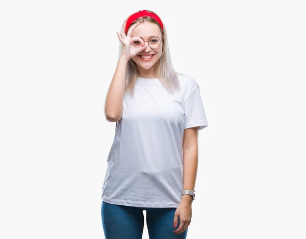 年轻的金发女人戴着眼镜在孤立的背景下做 手势用手微笑 眼睛看通过手指与愉快的面孔 — 图库照片