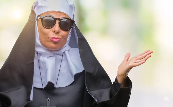 中年シニアのカトリック修道女女性のサングラスは 腕と手を上げて背景無知と混乱式を隔離しました 疑いのコンセプト — ストック写真
