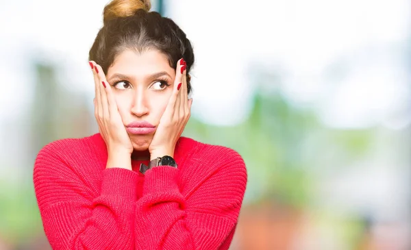 Young beautiful woman wearing red sweater and bun Tired hands covering face, depression and sadness, upset and irritated for problem