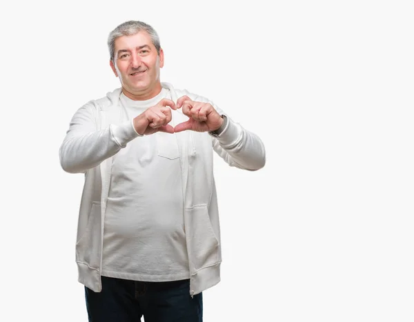 ハートマークと手で形を示す愛の笑みを浮かべて隔離された背景にスポーツ服を着てハンサムな年配の男性 ロマンチックな概念 — ストック写真