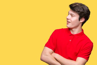 İkna ve kendine güvenen tarafına silahlarla seyir gülümseyen izole arka plan üzerinde kırmızı t-shirt giyen genç yakışıklı adam geçti