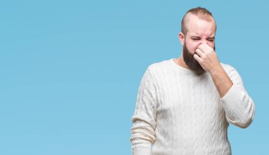 İzole arka plan kokulu üzerinde kış kazak pis ve iğrenç bir şey, dayanılmaz koku, holding nefes parmak ile burun üzerinde giyen genç beyaz hipster adam. Kötü kokuyor kavramı.