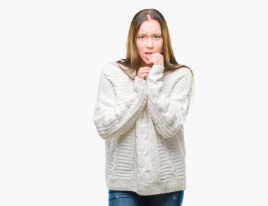 Stresli ve gergin elle çivi ısırma ağzına bakarak izole arka plan üzerinde kış kazak giyen genç güzel beyaz kadın. Anksiyete sorunu.