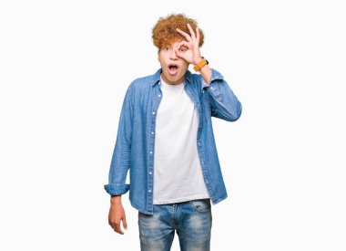 Sürpriz yüz, göz parmaklarının arasından seyir ile ok jest yapıyor kot ceket giyen afro saçlı Genç yakışıklı adam şok. İmansız ifade.