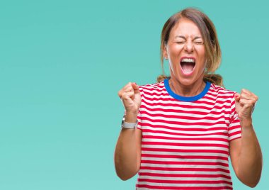 Orta yaş üst düzey İspanyol kadın yüzünden kızgın ve silah ile başarı için deli kutluyor izole arka plan ortaya çıkar ve heyecanlı çığlık gözler kapalı. Kazanan kavramı