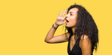 Genç güzel kız bağırarak ve ağzı üzerinde el ile yan için çığlık moda etek giyen kıvırcık saçlı. İletişim kavramı.