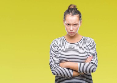 Genç güzel beyaz kadın izole arka plan şüpheci ve çapraz kolları olan yüzündeki gergin, onaylamayan ifade yüzünden. Negatif kişi.