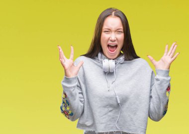 Üzerinde kulaklık giyen genç güzel beyaz öğrenci kadın arka plan deli kutluyor izole ve crazy arms ile başarı için kaldırdı ve heyecanlı çığlık gözler kapalı. Kazanan kavramı