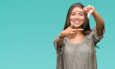 Genç güzel Arap kadın elle yapma çerçeve ve parmakları ile mutlu yüz gülümseyen izole arka plan yüzünden. Yaratıcılık ve Fotoğrafçılık kavramı.
