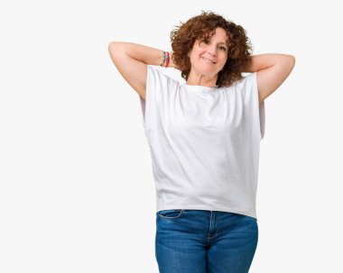 Arka plan üzerinde beyaz t-shirt giyen kadın güzel orta ager kıdemli izole rahatlatıcı ve kollar ve eller baş ve boyun, mutlu gülümseyerek arkasında ile germe