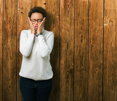 Genç güzel Afrikalı-Amerikalı kadın izole arka plan yorgun eller kat yüz, depresyon ve üzüntü, üzerinde gözlük üzgün ve sorun için tahriş