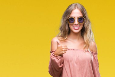 Güzel genç sarışın kadın hareketi el ile mutlu yaşasın yapıyor izole arka plan üzerinde Retro güneş gözlüğü takıyor. Kameraya bakarak başarı gösteren ile ifade onaylama.