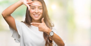 Genç güzel Arap kadın elle yapma çerçeve ve parmakları ile mutlu yüz gülümseyen izole arka plan yüzünden. Yaratıcılık ve Fotoğrafçılık kavramı.