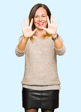 Gösterilen ve parmakları ile işaret güzel orta yaş kadın giyiyor moda kazak kendinden emin ve mutlu gülümseyerek süre on numara.