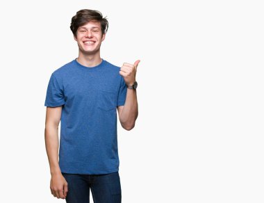 Hareketi el ile mutlu yaşasın yapıyor izole arka plan üzerinde mavi t-shirt giyen genç yakışıklı adam. Başarı gösteren kameraya bakarak ifade onaylama.