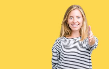 Giyen güzel genç kadın kazak dostu sunan karşılıklı tebrik ve davet edici gülümseyen izole arka plan üzerinde çizgili. Başarılı iş.