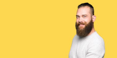 Açık el ile doğal gülümseyen girmek için rahat kazak davet giyen genç sarışın adam