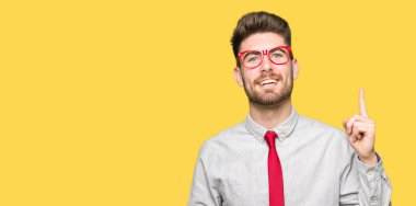 Başarılı fikirle parmağı yukarıyı gözlüklü genç yakışıklı iş adamı. Çıktıktan ve mutlu. Bir numara.