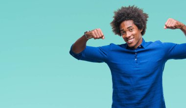 Kol kasları gururlu gülümseyen gösterilen izole arka plan üzerinde Afro Amerikalı adam. Fitness kavramı.