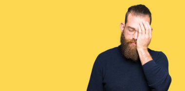 Genç Sarışın giyen gözlük ve balıkçı yaka kazak yarım yüz, göz ve ağız el ile kapsayan yorgun esneme adam. Acı yüzü acıyor.