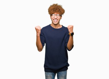 Afro kutluyor gözlük takan genç yakışıklı adamla şaşırttı ve başarı için kaldırdı kollarını açarak hayret ve gözleri açık. Kazanan kavramı.
