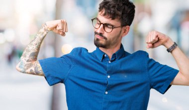 Kol kasları gururlu gülümseyen gösterilen izole arka plan üzerinde gözlük takan yakışıklı delikanlı. Fitness kavramı.