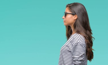 Genç güzel Arap kadın giyiyor güneş gözlüğü izole arka tarafına, seyir üzerinde dinlenmek doğal yüz emin gülümseme ile pozuyla profili.