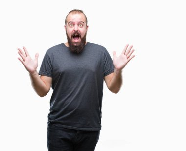 Genç beyaz hipster adam deli kutluyor arka plan izole ve başarı için kaldırdı kollarını açarak hayrete ve heyecanlı çığlık gözleri açık. Kazanan kavramı