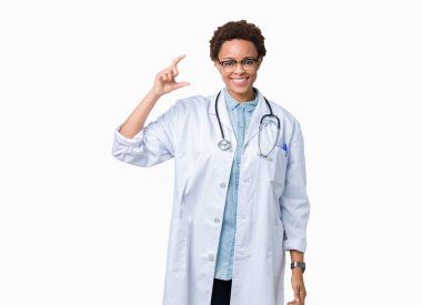 İzole arka plan gülümseyen ve boyutu işaret parmaklı ararken ve kamera işi el ile kendinden emin eller üzerinde tıbbi ceket giyen genç Afro-Amerikan doktor kadın. Ölçü kavramı.