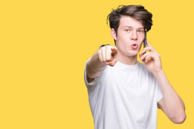 Genç adam Smartphone'da konuşmayı kamera ve size parmak ile işaret arka plan izole, el işareti, pozitif ve kendinden emin bir jest ön