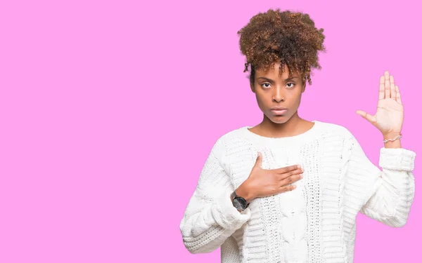 上冬のセーターを着ている美しい若いアフリカ系アメリカ人女性の背景を分離した胸とオープンの手のひら 忠誠の宣誓で手宣誓 — ストック写真