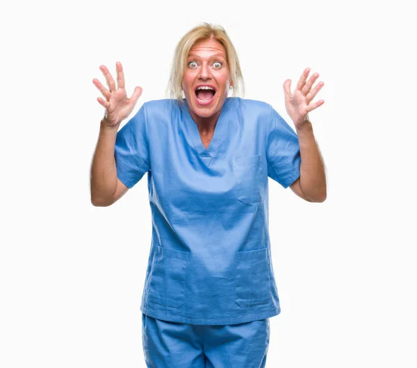 中年金髪女性の身に着けている医師クレイジーを祝う孤立の背景に看護師の制服と叫んで興奮発生と開いた目の腕の成功のため驚きます 勝者の概念 — ストック写真