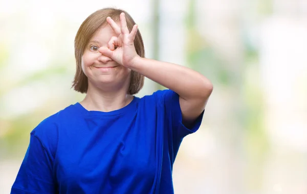 幸せそうな顔で指を通して見る目の手で のジェスチャーを行う分離の背景にダウン症候群の若い成人女性 — ストック写真