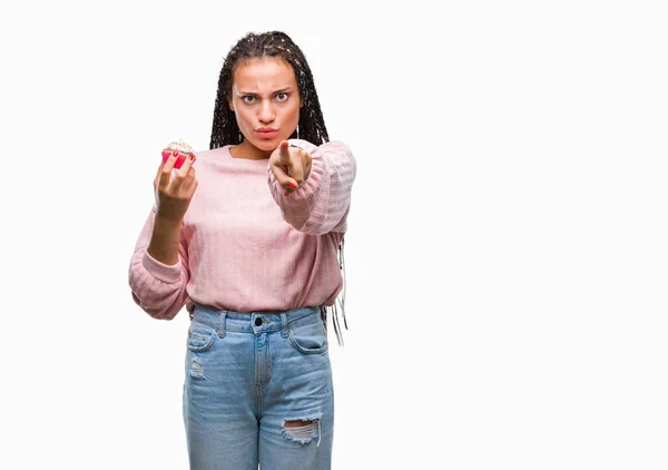 アフリカ系アメリカ人少女にカップケーキを食べて分離カメラと指で指している背景 手署名 正面からポジティブで自信のジェスチャー — ストック写真