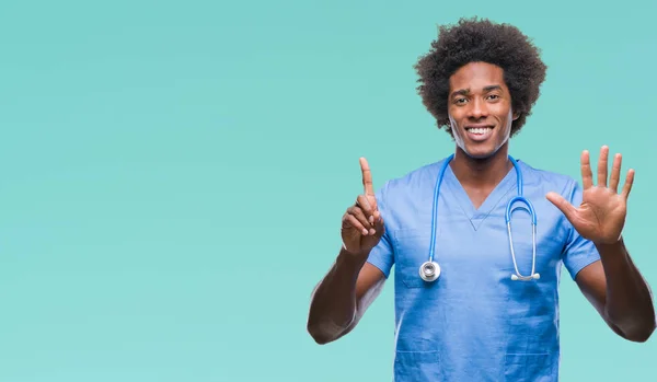 非裔美国外科医生男子在孤立的背景显示和指向用手指数字六 同时微笑着自信和快乐 — 图库照片