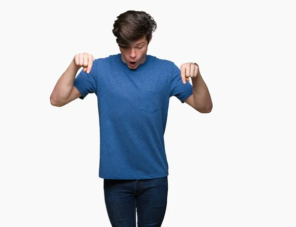 年轻英俊的男人穿着蓝色的 T恤在孤立的背景下 用手指指着广告 惊讶的脸和张开的嘴 — 图库照片