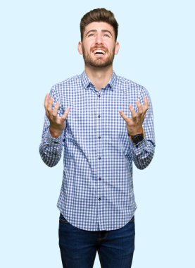 Genç yakışıklı bussines çılgın ve kızgın bağırarak ve agresif ifade ve silah kaldırdı bağırmaya dostum. Hayal kırıklığı kavramı.