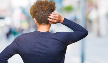 Yakışıklı delikanlı afro saçlar geriye düşünce hakkında şüphe ile kafasına el ile