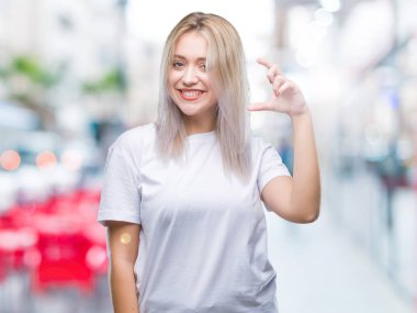 Genç Sarışın kadın izole arka plan gülümseyen ve süre seyir ve kamera boyutu işaret parmaklarıyla yapıyor el ile kendine güvenen el hareketi yüzünden. Ölçü kavramı.